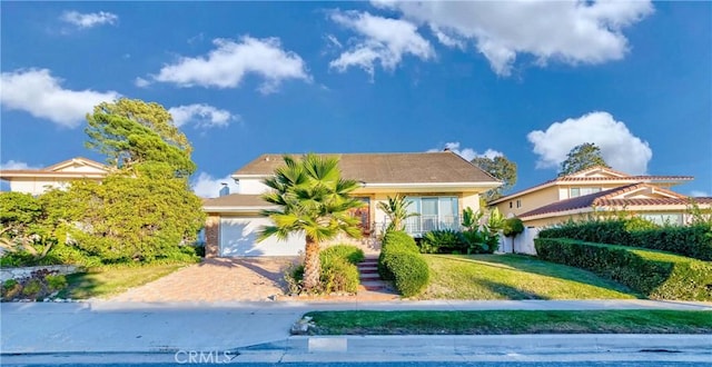 view of front of property featuring a front lawn, decorative driveway, an attached garage, and stucco siding