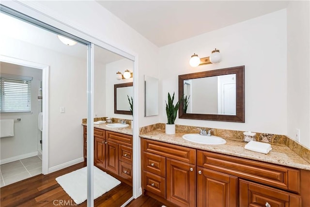 bathroom featuring vanity, baseboards, and wood finished floors