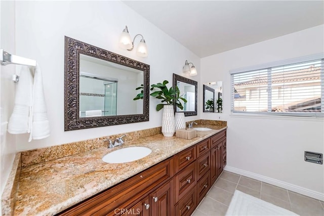 full bath featuring double vanity, tile patterned flooring, baseboards, and a sink