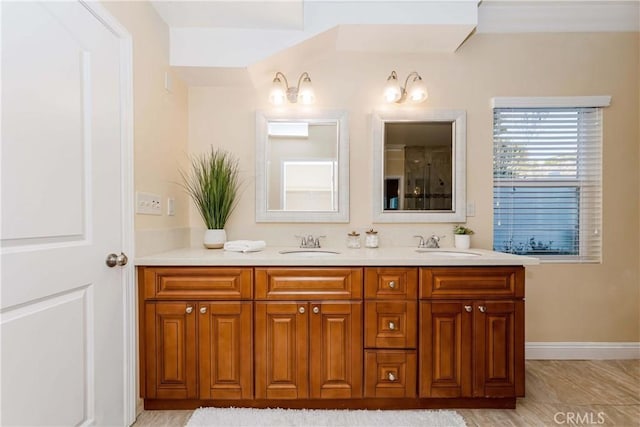 full bathroom featuring double vanity, a sink, and baseboards