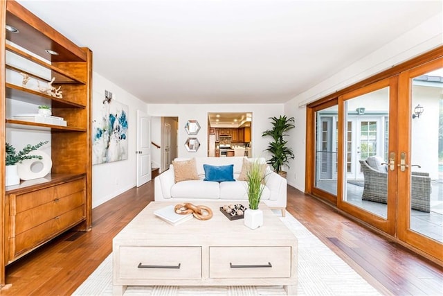 living area with baseboards, dark wood finished floors, and french doors