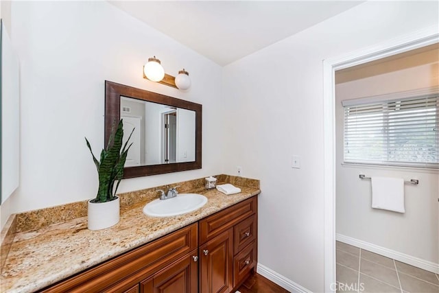 bathroom with tile patterned flooring, vanity, and baseboards