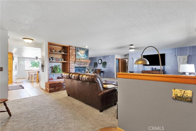 living area featuring light colored carpet, a fireplace, a textured ceiling, and light tile patterned floors