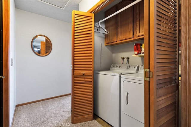 laundry room featuring light colored carpet, cabinet space, a textured ceiling, independent washer and dryer, and baseboards