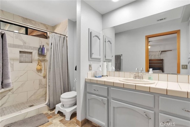 bathroom featuring visible vents, toilet, a stall shower, and vanity