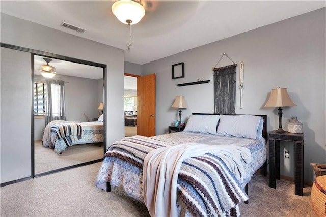 bedroom with a ceiling fan, carpet, visible vents, and a closet