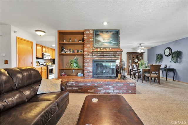 living area featuring a textured ceiling, carpet, a ceiling fan, and a brick fireplace