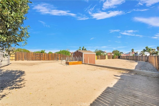 view of yard with a storage unit, an outdoor structure, and a fenced backyard