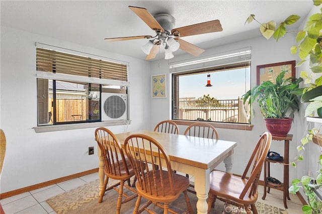 dining space with baseboards, a ceiling fan, and light tile patterned flooring