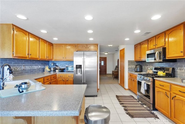 kitchen featuring light tile patterned floors, visible vents, appliances with stainless steel finishes, light countertops, and a sink