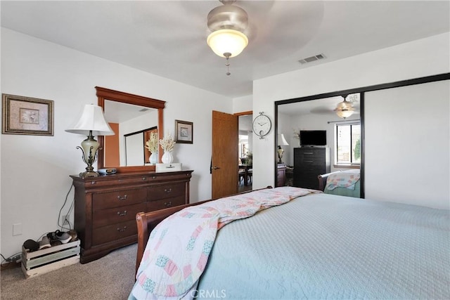 bedroom with ceiling fan, a closet, visible vents, and light colored carpet