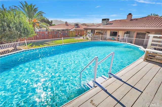 view of pool with a fenced in pool, central AC, and fence