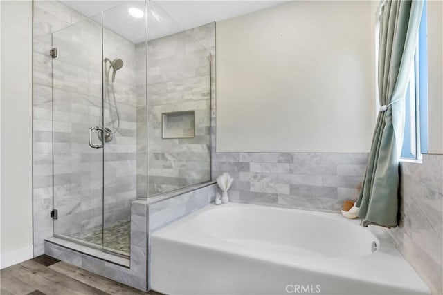 bathroom featuring wood finished floors, a shower stall, and a bath