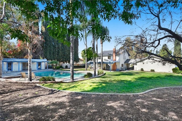 view of community with a pool, a yard, and a patio