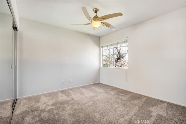 unfurnished room featuring ceiling fan and carpet