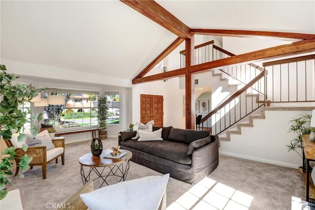 living room with beam ceiling, light colored carpet, high vaulted ceiling, baseboards, and stairs