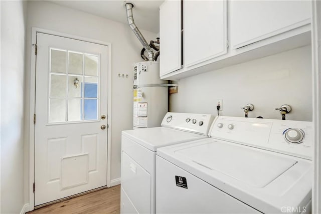 washroom with baseboards, light wood-style floors, secured water heater, cabinet space, and washing machine and clothes dryer