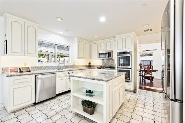 13440 Pala Ave, Sylmar, CA 91342 - kitchen with appliances with stainless steel finishes, a sink, open shelves, white cabinetry, and recessed lighting