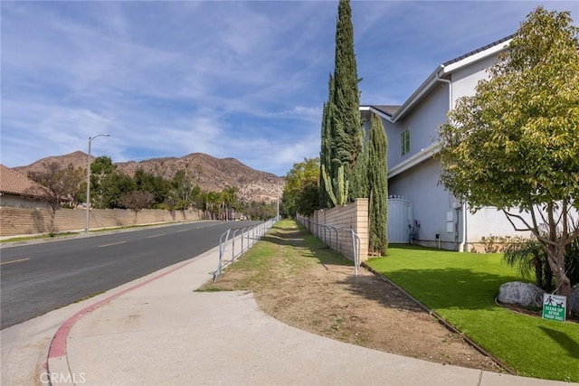 13440 Pala Ave, Sylmar, CA 91342 - view of asphalt road with street lights, a mountain view, and sidewalks