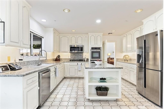 13440 Pala Ave, Sylmar, CA 91342 - kitchen with stainless steel appliances, open shelves, white cabinets, light stone countertops, and recessed lighting