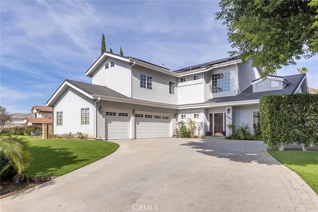 view of front of house with a garage, driveway, solar panels, a front lawn, and stucco siding