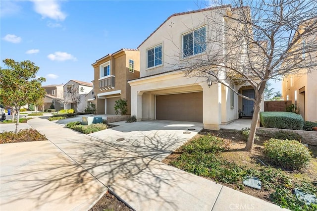 view of front of property featuring an attached garage, a residential view, concrete driveway, and stucco siding