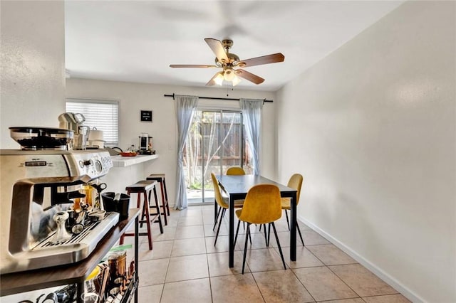 dining area featuring ceiling fan, light tile patterned flooring, and baseboards