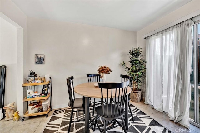 dining area with baseboards and light tile patterned floors