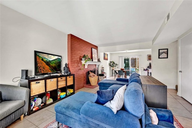 living area featuring a fireplace, visible vents, and light tile patterned flooring