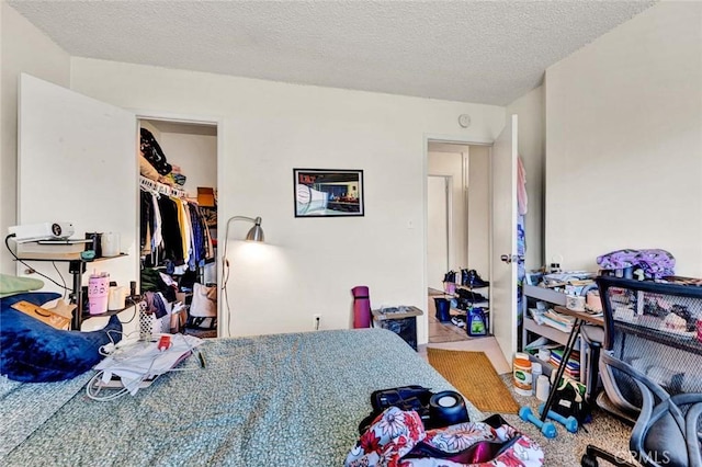 bedroom with a textured ceiling and a spacious closet