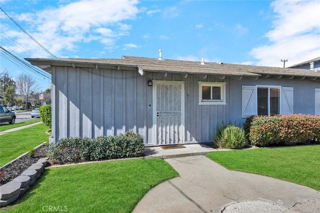 entrance to property featuring a yard and board and batten siding