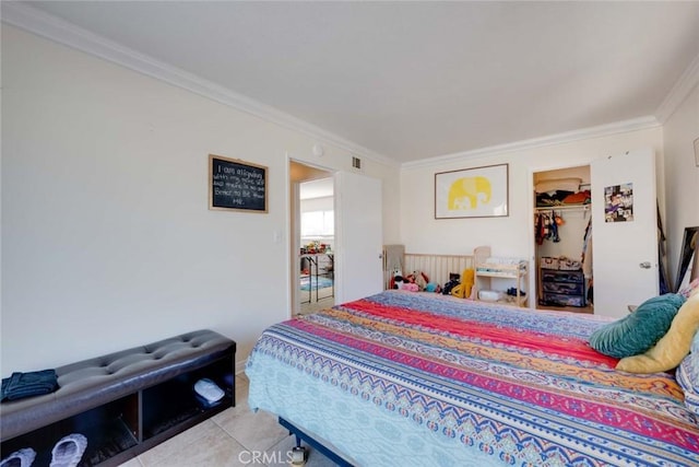 bedroom with light tile patterned floors, a closet, visible vents, a spacious closet, and ornamental molding