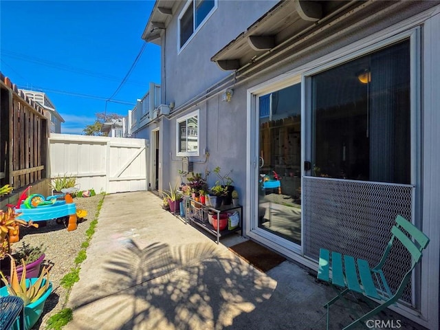 view of patio featuring fence and a gate