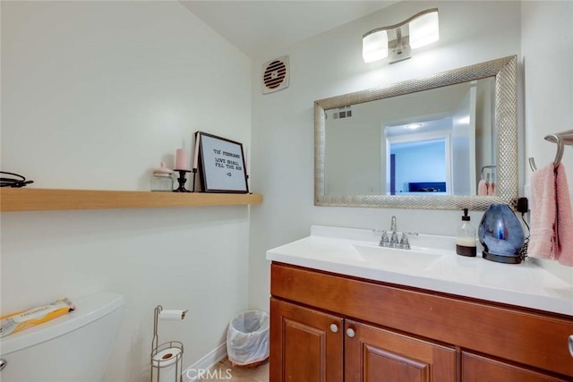 bathroom featuring toilet, vanity, and visible vents