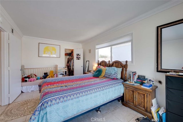 bedroom with light tile patterned floors, visible vents, a spacious closet, ornamental molding, and a closet