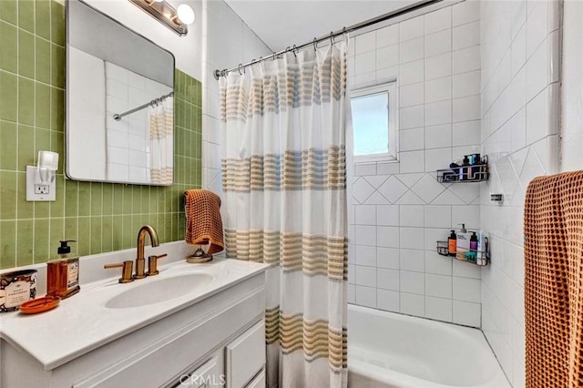 bathroom with shower / bath combo with shower curtain, tile walls, and vanity