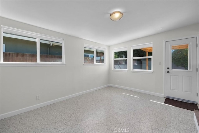carpeted empty room featuring baseboards