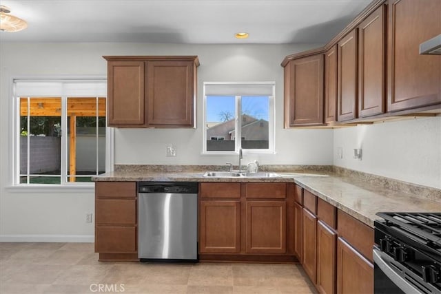 kitchen with recessed lighting, brown cabinets, a sink, and appliances with stainless steel finishes