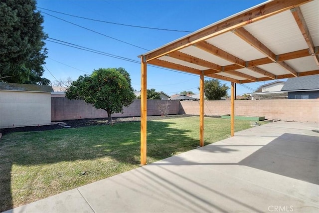 view of yard with a patio, a fenced backyard, and an outdoor structure