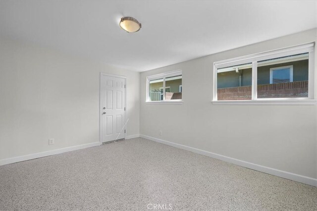 spare room featuring baseboards and speckled floor