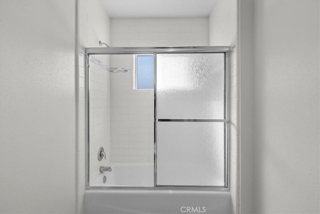 full bath featuring bath / shower combo with glass door