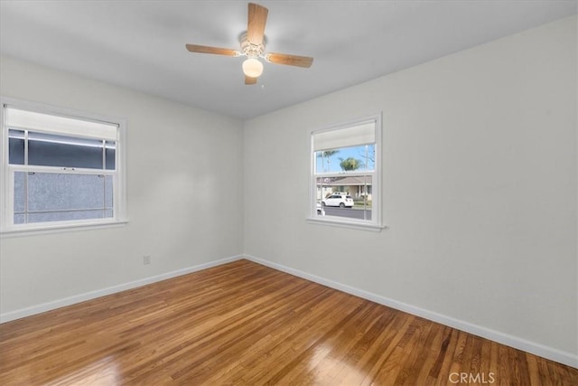 empty room with light wood-style flooring, ceiling fan, and baseboards