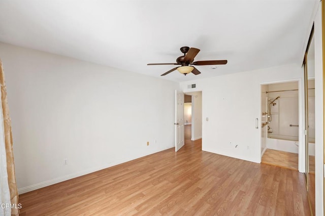 unfurnished bedroom with light wood-style floors, a ceiling fan, visible vents, and connected bathroom