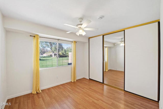 unfurnished bedroom featuring light wood finished floors, a closet, a ceiling fan, and baseboards