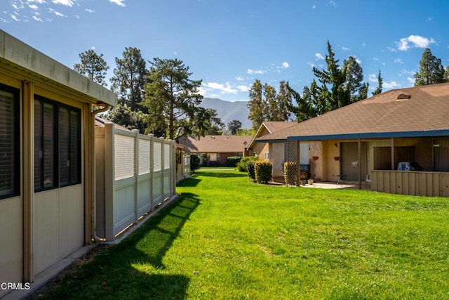 view of yard with a patio area, fence, and a mountain view