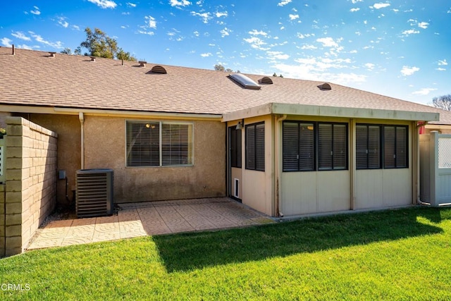 back of property featuring a patio, central air condition unit, a shingled roof, fence, and a lawn