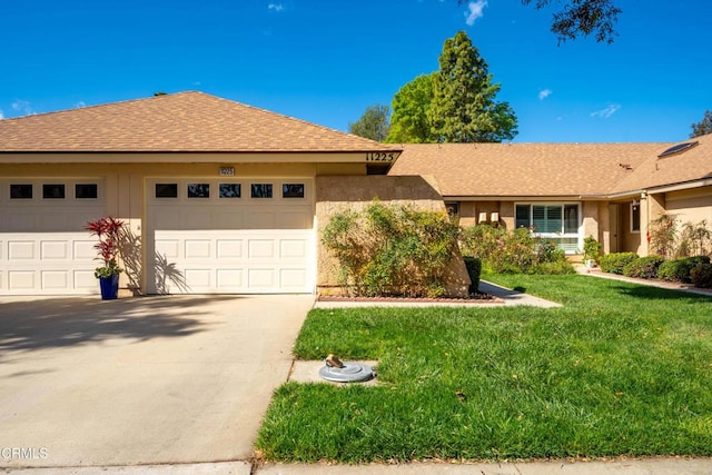 single story home with an attached garage, driveway, a front lawn, and a shingled roof