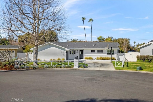 view of front of house featuring driveway, a gate, and fence