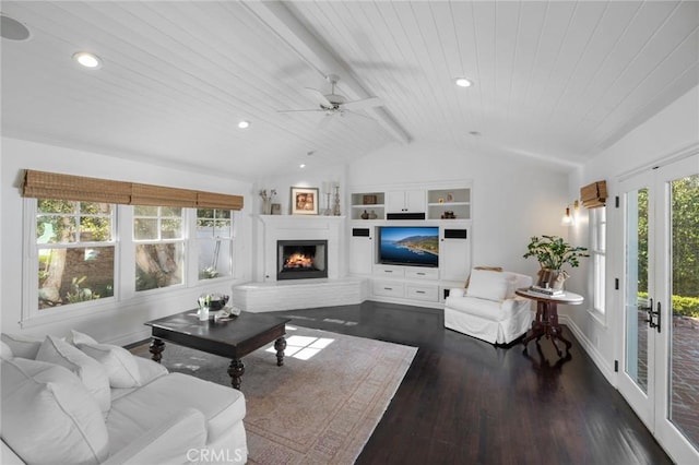 living area with lofted ceiling with beams, wood ceiling, wood finished floors, a lit fireplace, and recessed lighting