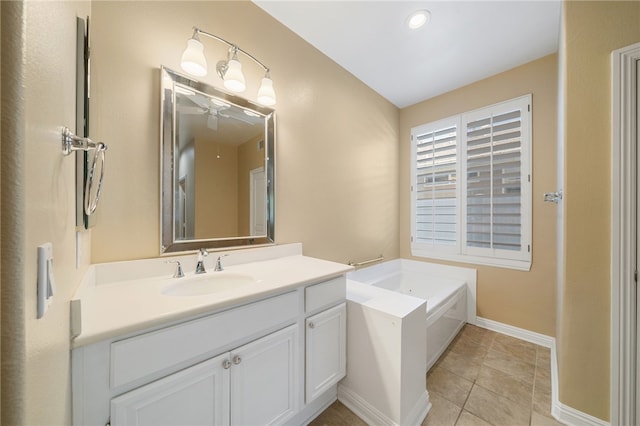 full bath featuring baseboards, a garden tub, vanity, and tile patterned floors